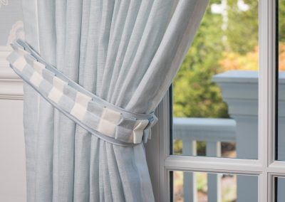 Newton homes, window treatment details, tiebacks, drapery tiebacks, pleats, pleated detail, blue and white stripe fabric, french door, balcony, bedroom balcony, Newton